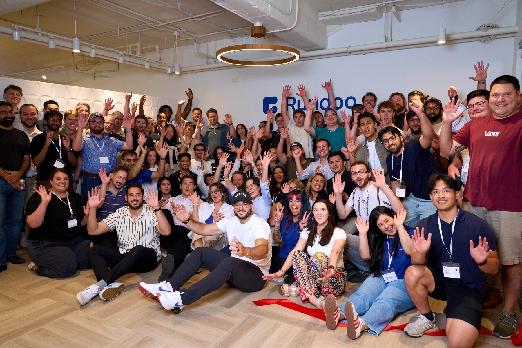 The Rundoo team celebrating in front of the Rundoo logo