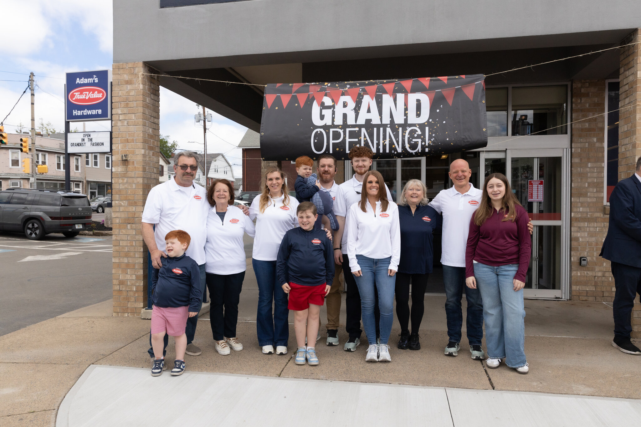 The Taffera family gathered under the Grand Opening banner outside Adam's True Value Hardware