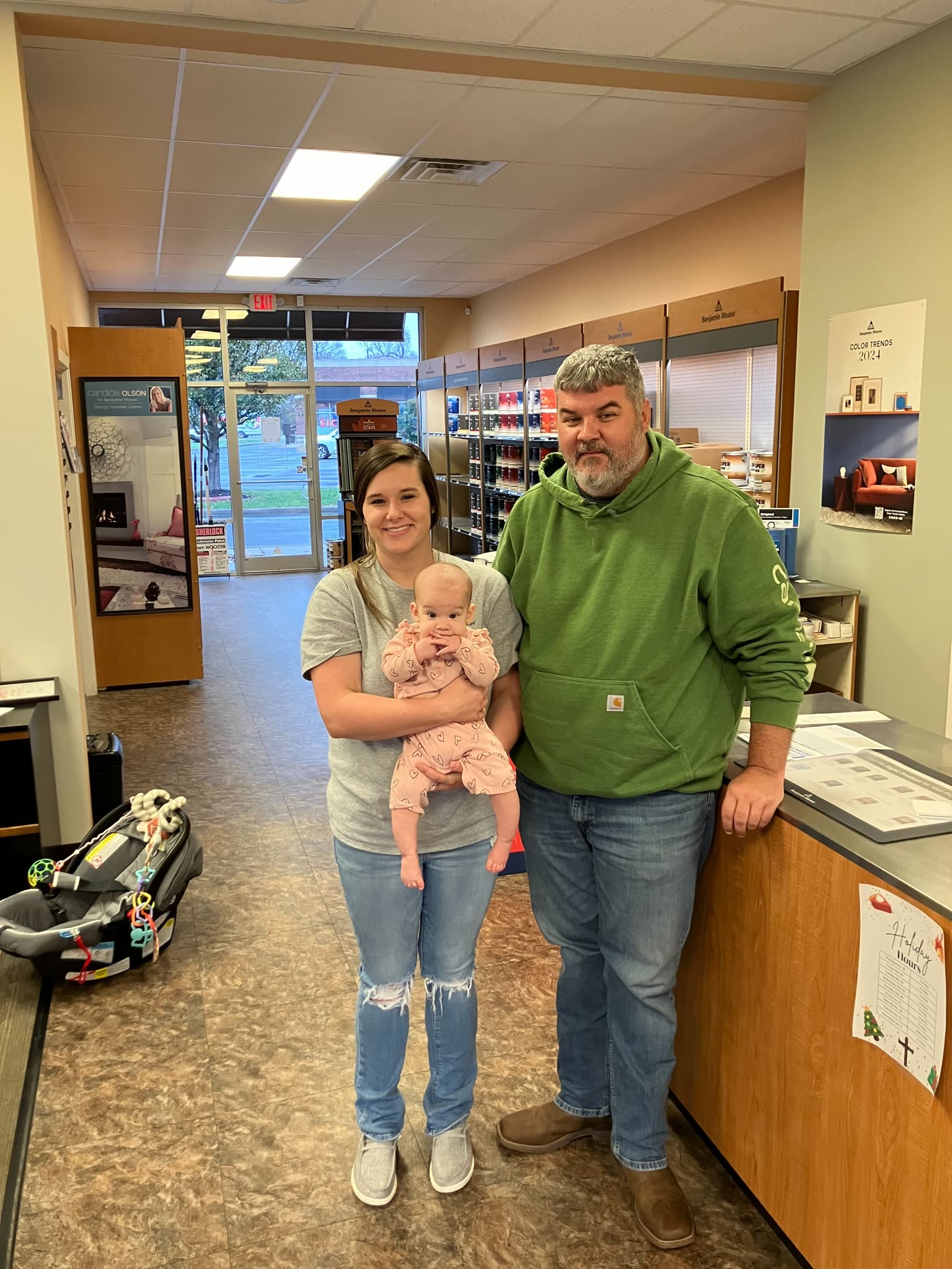 A family at the front counter of Bardstown Paint and Design Center, beside the Benjamin Moore color displays